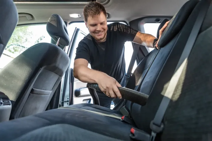 Pro Shine team member vacuuming car interior